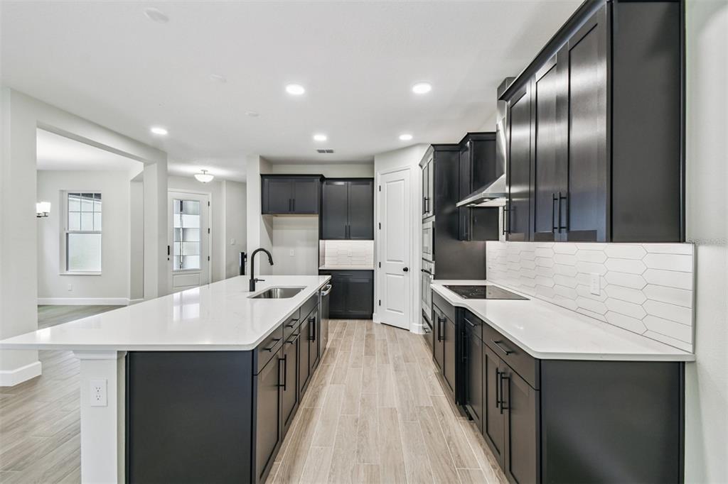 5262 Prairie Preserve Run St. Cloud, FL 34772 - Photo 6 of 40 a large kitchen with kitchen island a sink stove and refrigerator