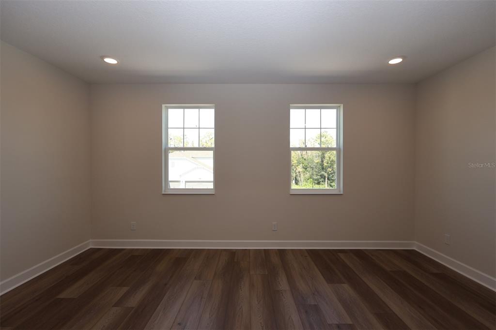 5262 Prairie Preserve Run St. Cloud, FL 34772 - Photo 8 of 40 an empty room with wooden floor and windows