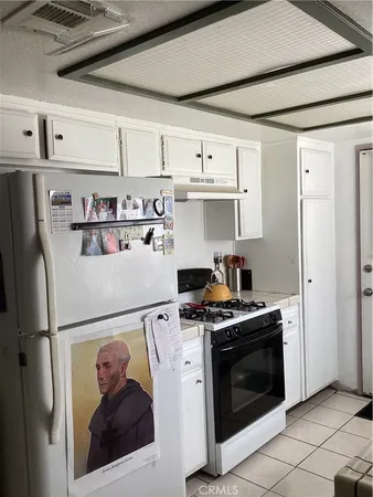 a white refrigerator freezer and a stove sitting inside of a kitchen