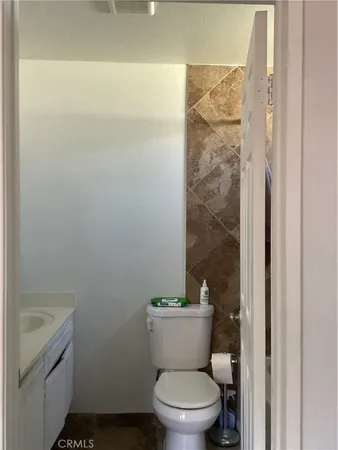 a white toilet sitting next to a bathroom sink