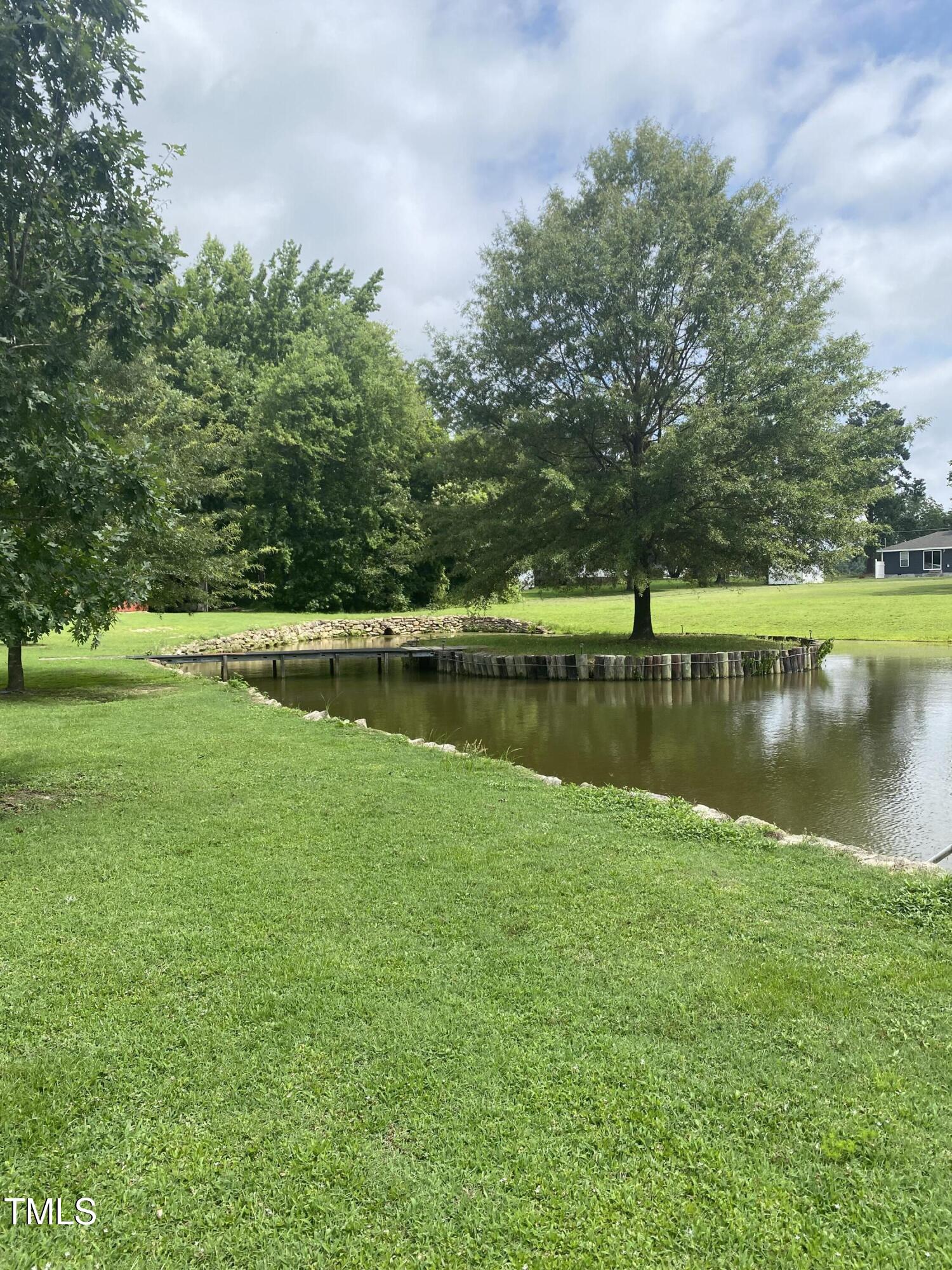 920 Vanco Mill Road Henderson, NC 27537 - Photo 15 of 26 a view of a lake with a big yard and large trees