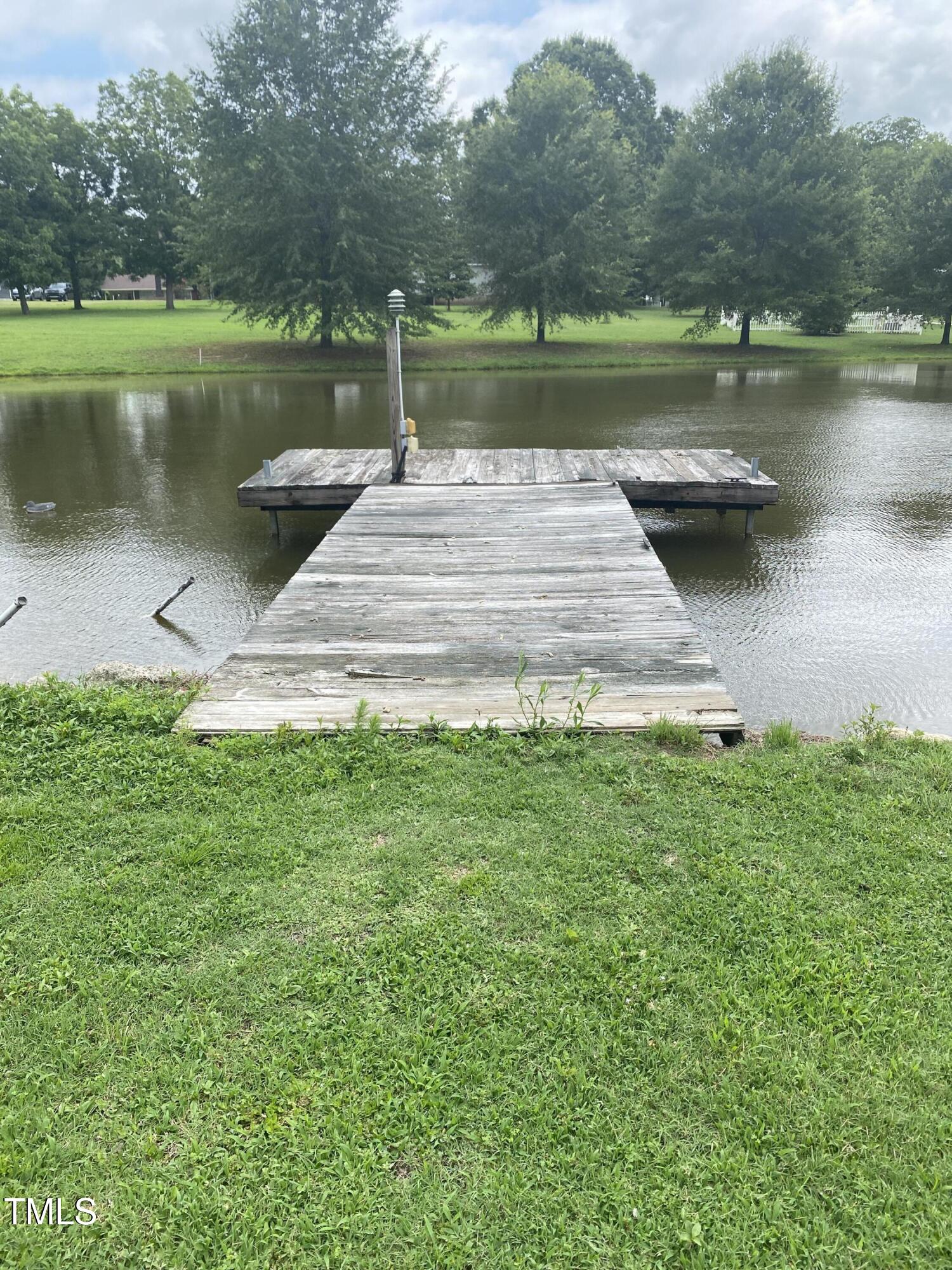 920 Vanco Mill Road Henderson, NC 27537 - Photo 16 of 26 a view of a lake with a yard and large trees