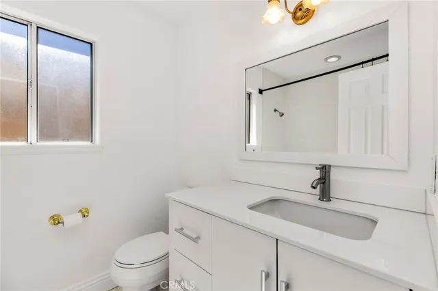 a bathroom with a sink a toilet and mirror
