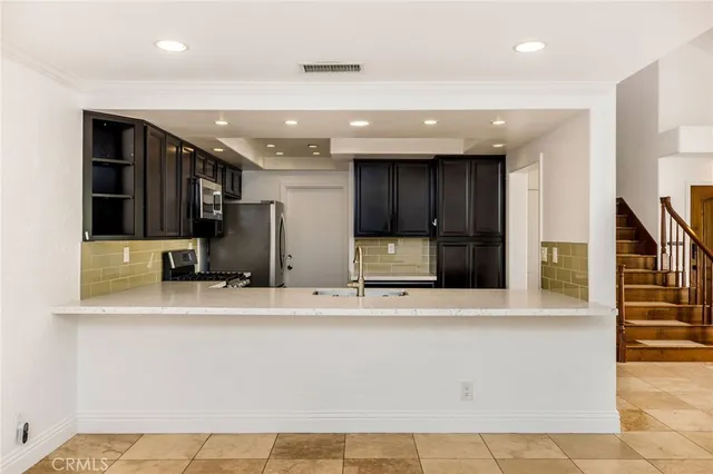 a view of a kitchen with stainless steel appliances granite countertop a refrigerator and a sink