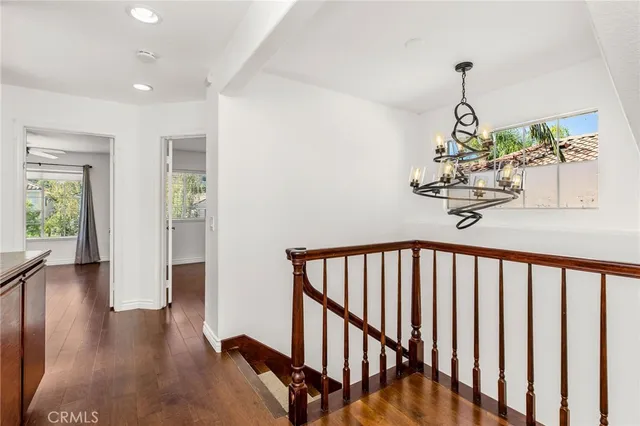 a view of a hallway with wooden floor and stairs