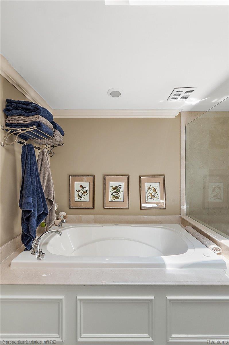 135 Clifton Road Bloomfield Hills, MI 48301 - Photo 41 of 77 Built-in soaking tub featuring a chrome faucet, light-toned countertop, paneled surround, and crown molding