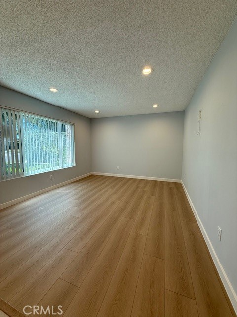 8772 Candlewood Street Rancho Cucamonga, CA 91730 - Photo 2 of 2 an empty room with wooden floor and windows