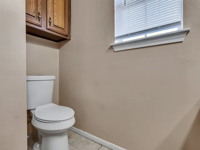 a white toilet sitting next to a window
