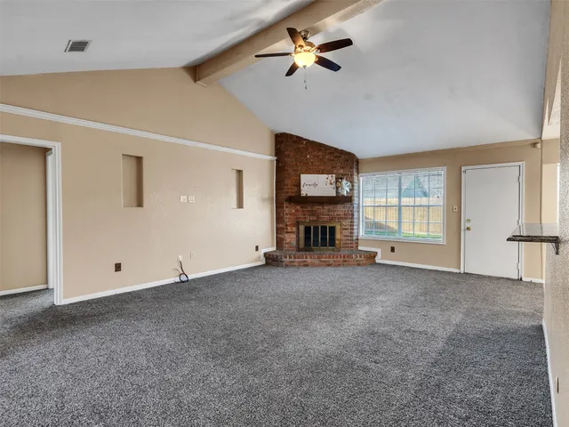 a view of empty room with fireplace and fan