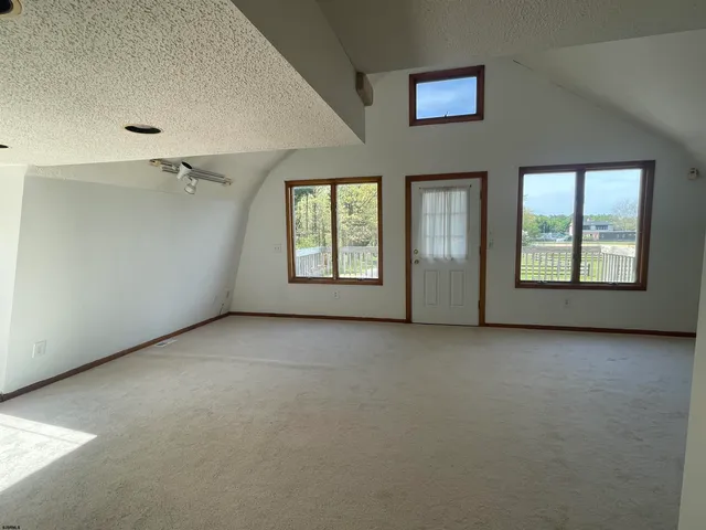 an empty room with windows and cabinet