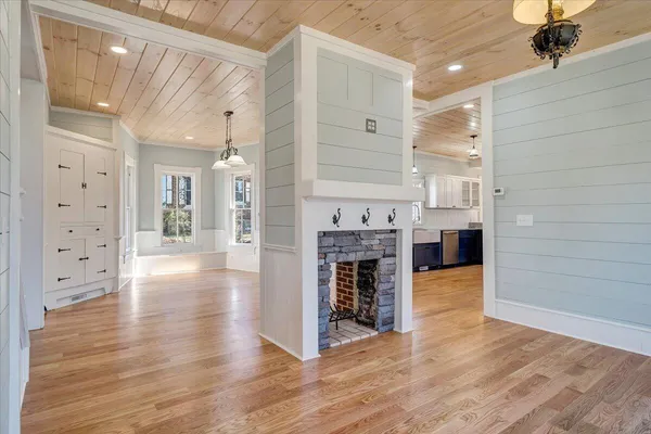 a view of a room with wooden floor fireplace and windows