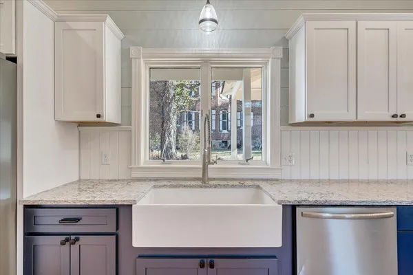 a bathroom with a sink a toilet a mirror a vanity and window