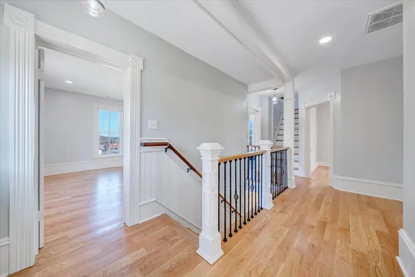 a view of a hallway with wooden floor and staircase