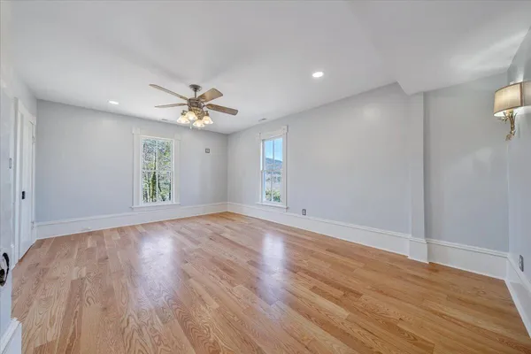 a hallway with wooden floor chandelier and entryway