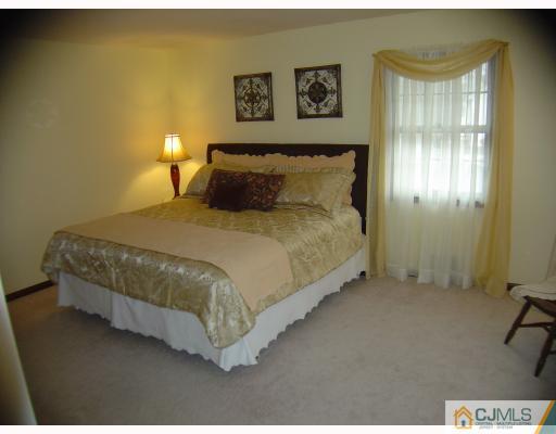 276 Hamlin Road North Brunswick, NJ 08902 - Photo 6 of 10 a bedroom with a bed and a night stand