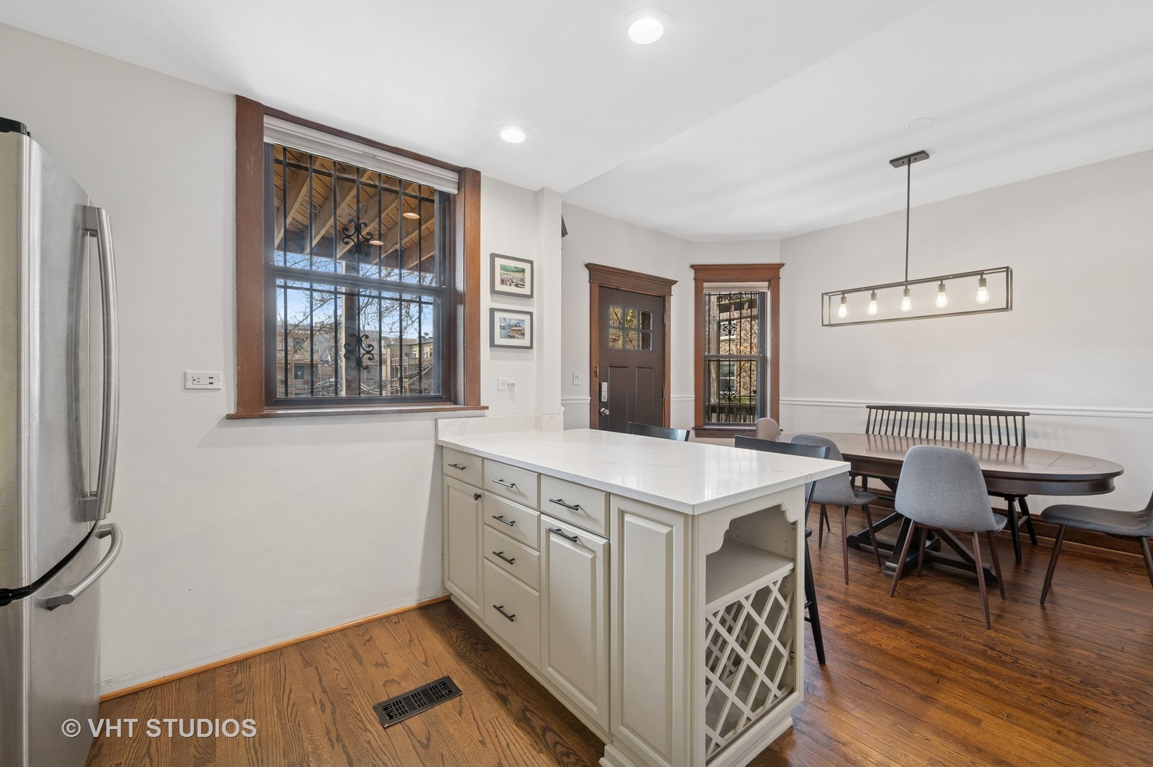 845 West Grace Street, Unit 2W Chicago, IL 60613 - Photo 7 of 21 a open kitchen with stainless steel appliances granite countertop a stove top oven a dining table and chairs with wooden floor