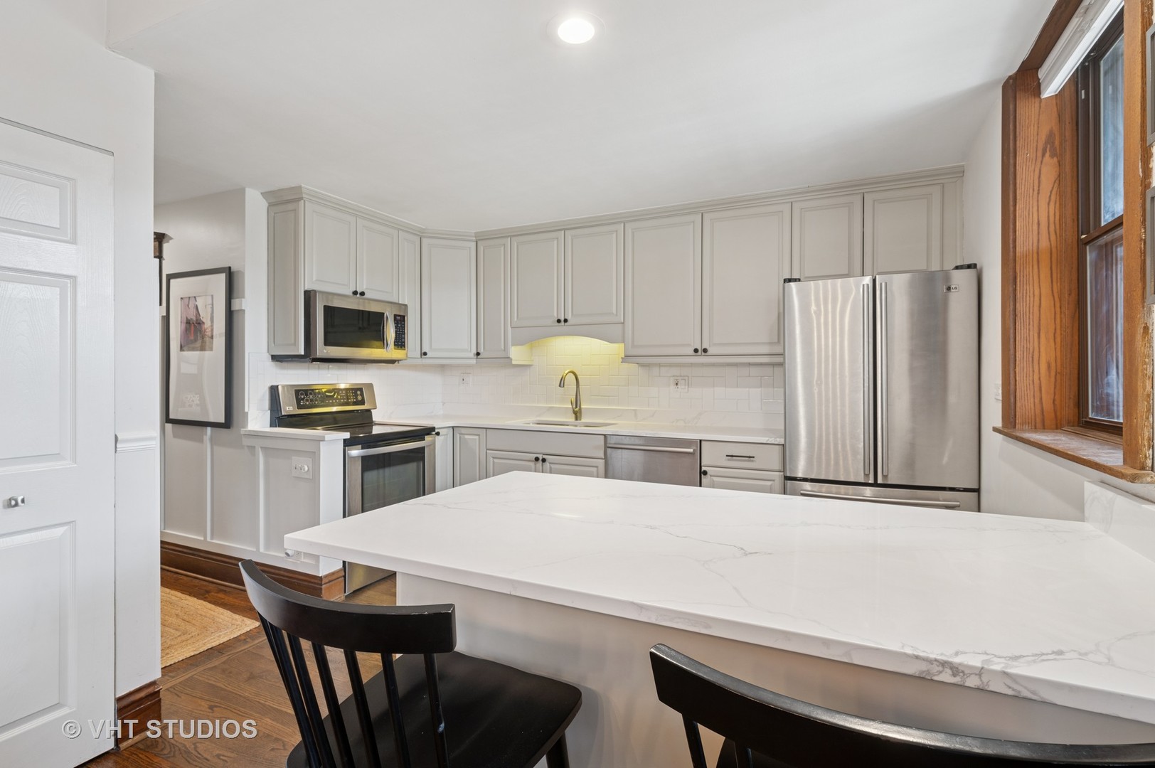 845 West Grace Street, Unit 2W Chicago, IL 60613 - Photo 9 of 21 a kitchen with stainless steel appliances a refrigerator a stove a sink a dining table and chairs