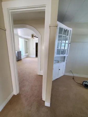 a view of a hallway with wooden floor and a livingroom view