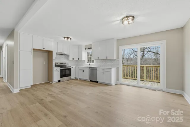 a large white kitchen with a stove top oven and refrigerator