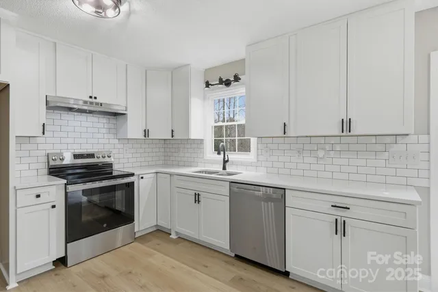 a kitchen with white cabinets stainless steel appliances and sink