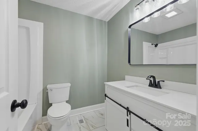 a bathroom with a sink a toilet and a mirror