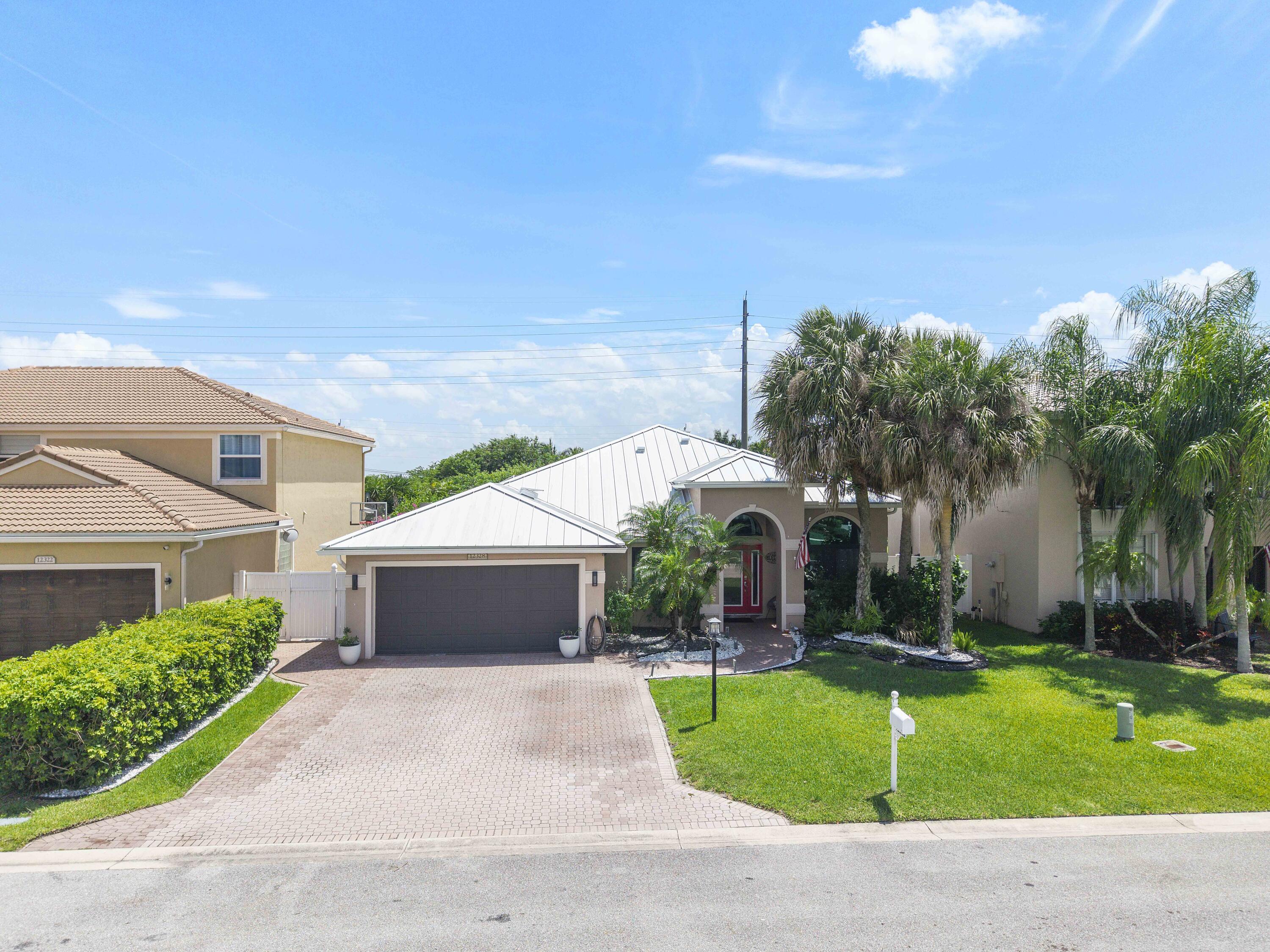 12328 St Simon Drive Boca Raton, FL 33428 - Photo 38 of 52 a front view of a house with a yard and garage