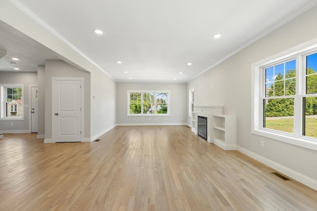 28 Riverview Road, Unit A Gloucester, MA 01930 - Photo 13 of 36 an empty room with wooden floor fireplace and windows