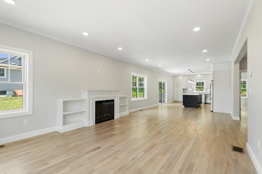 28 Riverview Road, Unit A Gloucester, MA 01930 - Photo 14 of 36 an empty room with wooden floor fireplace and windows