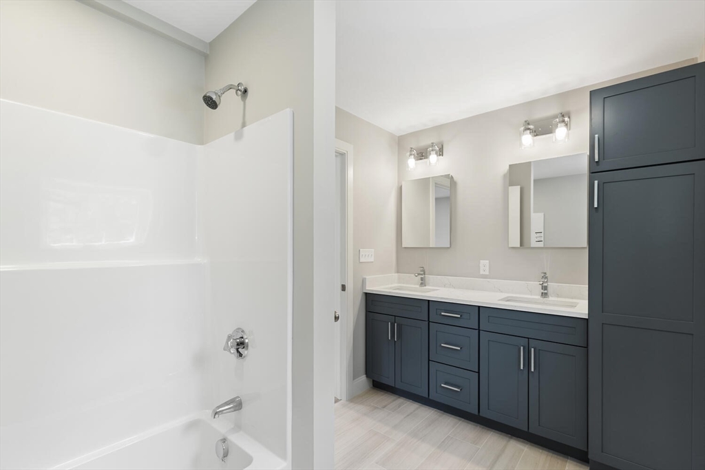 28 Riverview Road, Unit A Gloucester, MA 01930 - Photo 26 of 36 a bathroom with a double vanity sink and mirror with shower