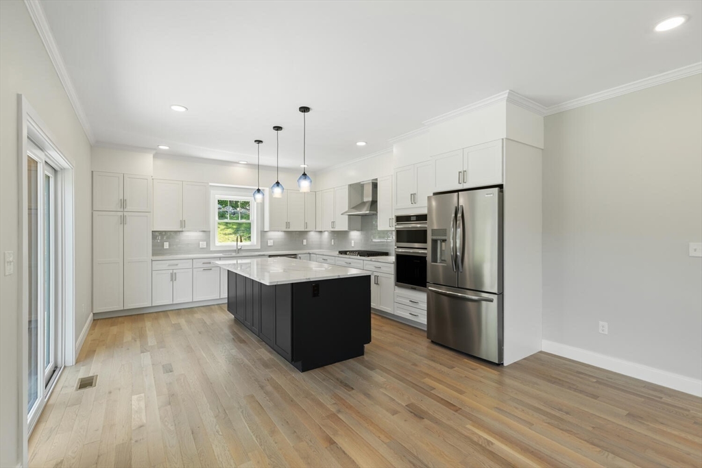 28 Riverview Road, Unit A Gloucester, MA 01930 - Photo 5 of 36 a kitchen with wooden floors and stainless steel appliances