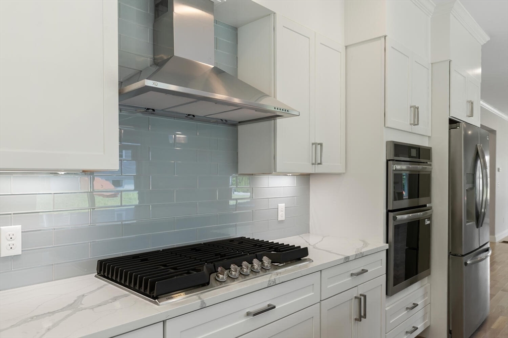 28 Riverview Road, Unit A Gloucester, MA 01930 - Photo 8 of 36 a kitchen with granite countertop a stove and a refrigerator
