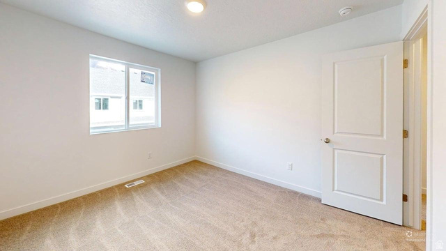 783 Pheasantbrook Drive, Unit 2A Centerville, UT 84014 - Photo 27 of 41 Neutral-toned carpeting paired with white walls, a single window, and a paneled door