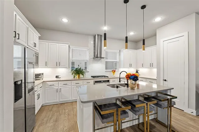 a kitchen with a sink cabinets and chairs