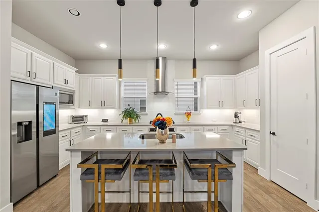 a kitchen with kitchen island white cabinets and stainless steel appliances