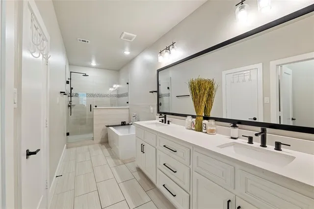 a bathroom with a double vanity sink mirror and shower