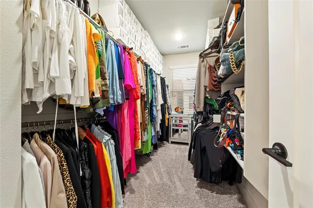 a view of walk in closet with clothes