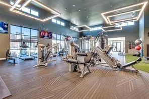 a living room with couches and kitchen view with wooden floor
