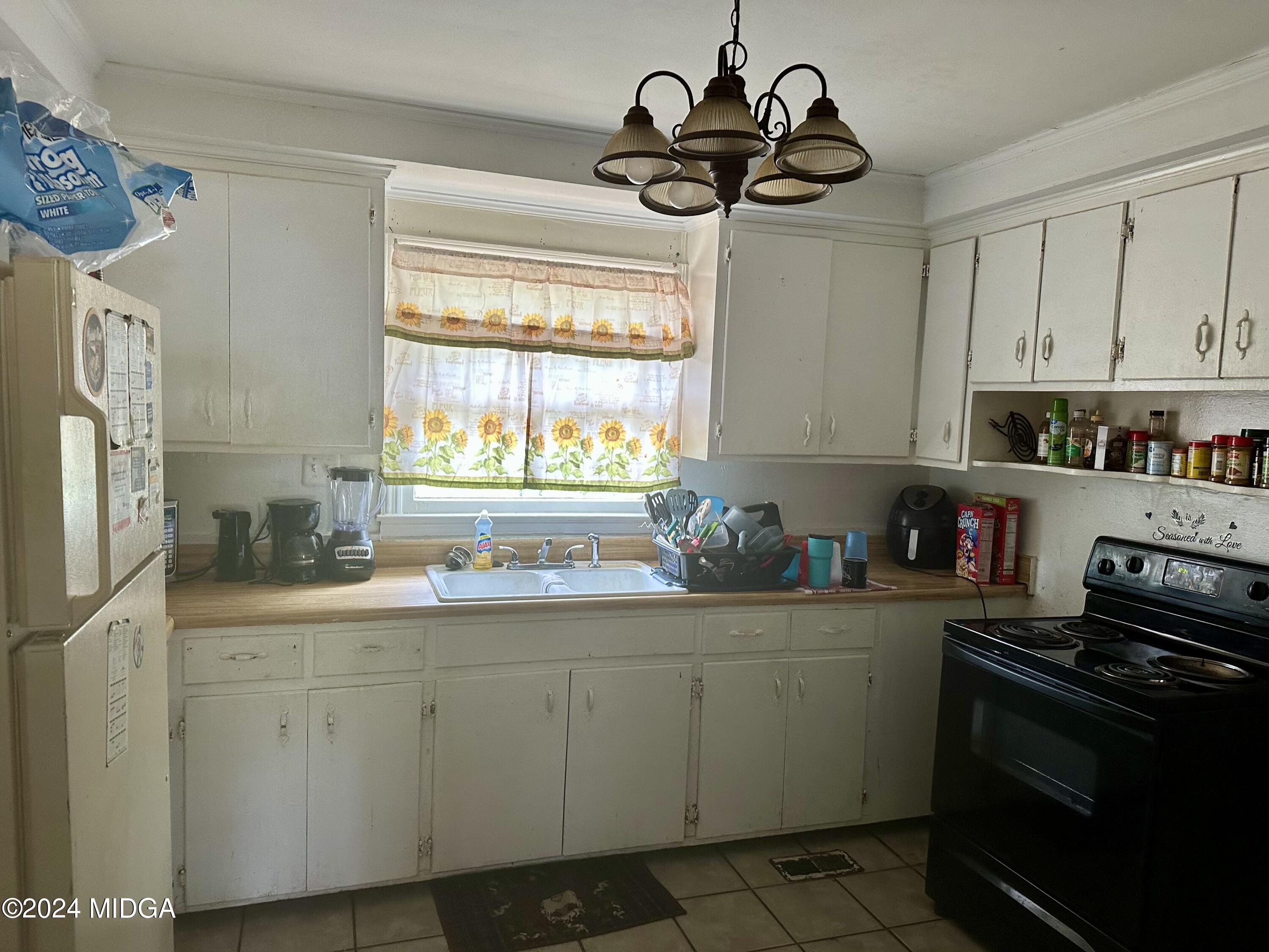 2048 Knightsbridge Road Macon, GA 31211 - Photo 4 of 9 a kitchen with a sink appliances cabinets and a window