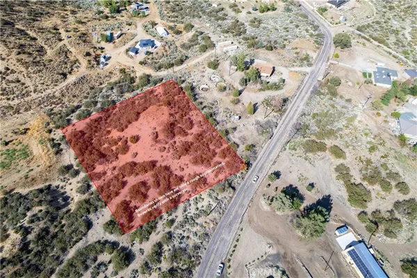 a view of a dry yard with lots of bushes