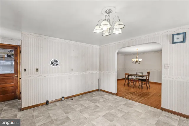 wooden floor in a hall with a dining table chairs