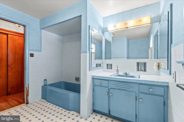 a en suite bathroom with a sink a large mirror and a bathtub