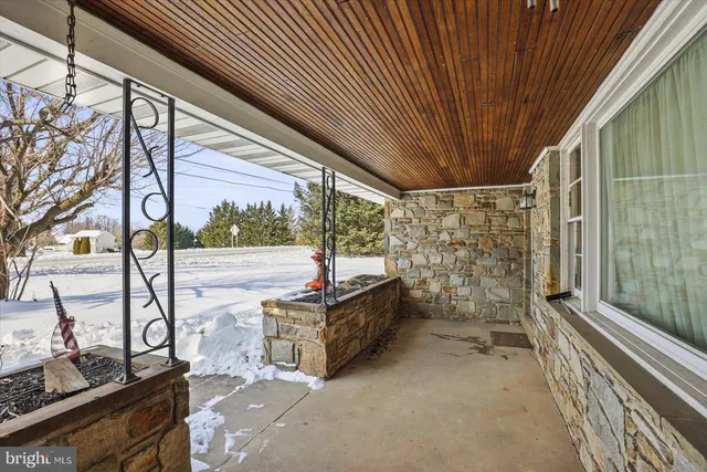 a view of a porch with wooden floor and iron stairs