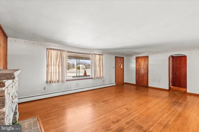an empty room with window and wooden floor