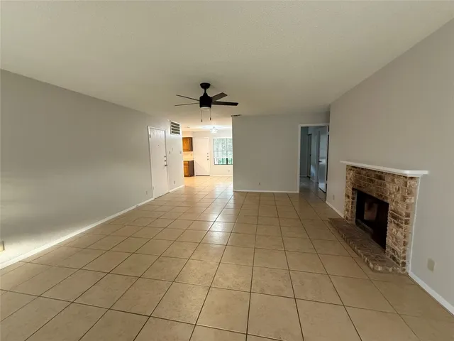 a view of an empty room with a fireplace and a window