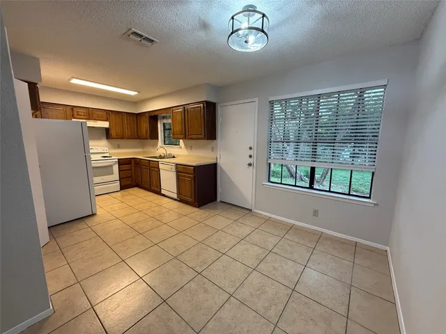 a kitchen with stainless steel appliances a refrigerator and a stove top oven