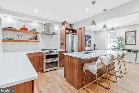 a kitchen with granite countertop a table chairs stove and cabinets