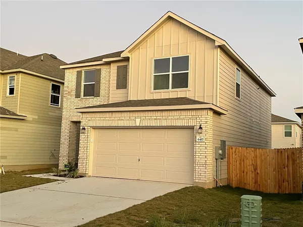 a view of a house with wooden fence