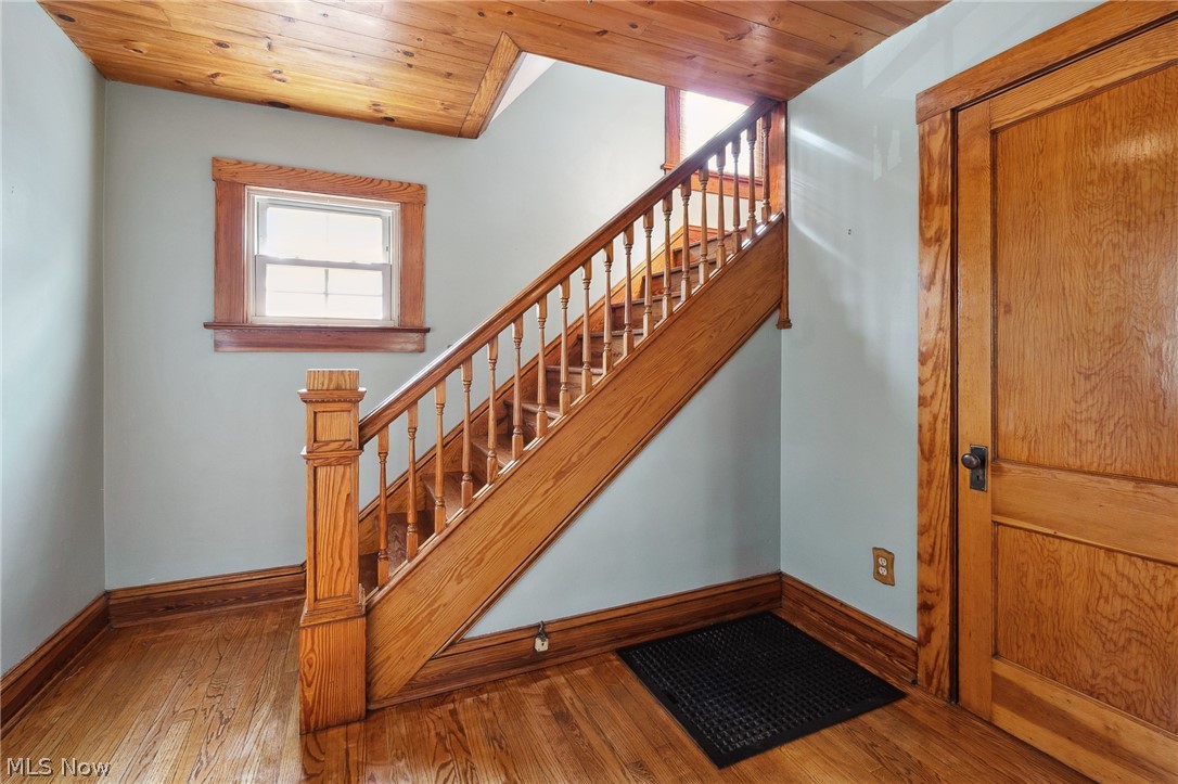 Stairway featuring wooden ceiling and light hardwood / wood-style floors