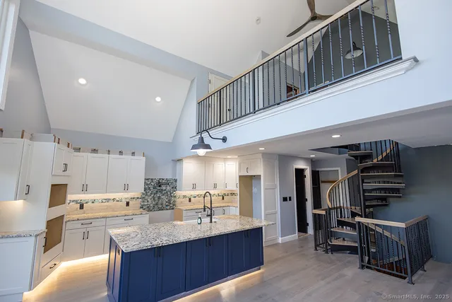 a kitchen with stainless steel appliances kitchen island granite countertop a refrigerator and a stove top oven