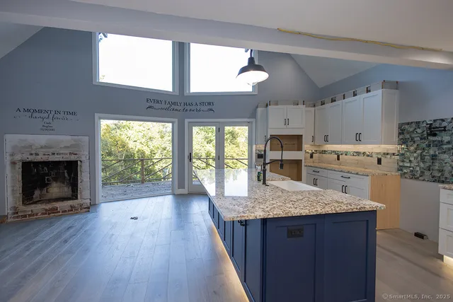 a kitchen with kitchen island granite countertop wooden floors and granite counter tops